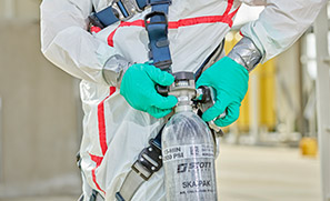 Fully clad in 3M safety apparel, a worker adjusts their supplied air cylinder.
