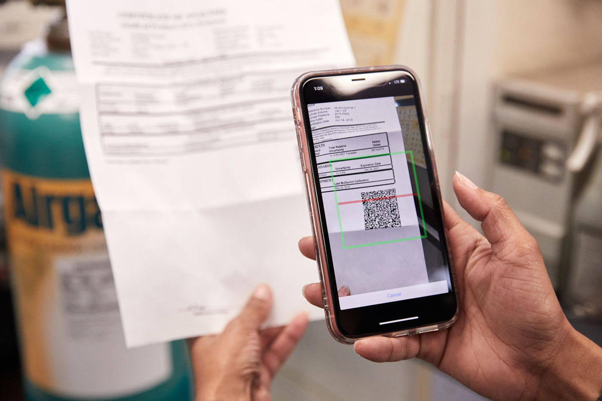 Airgas SRVS app shown on a phone next to a gas cylinder