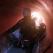 Workers in tunnel wearing confined space protective gear