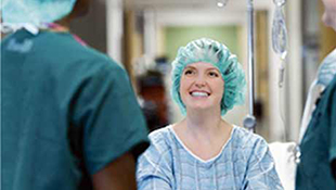 A medical professional speaking to a smiling patient.