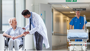 Set in a hospital, a doctor, surrounded by another doctor and a nurse, happily shakes hands with a man in a suit.