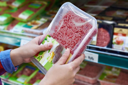Close-up of packaged ground beef kept fresh with Modified Atmosphere Packaging in the hands of a supermarket customer.