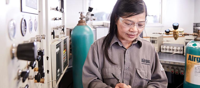 An Airgas Total Managed Services technician studies a form while working on a customer site.