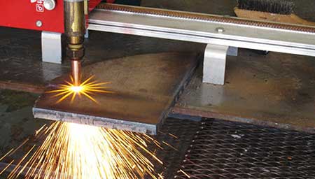Close up of oxy-fuel cutting torch cutting thick metal.