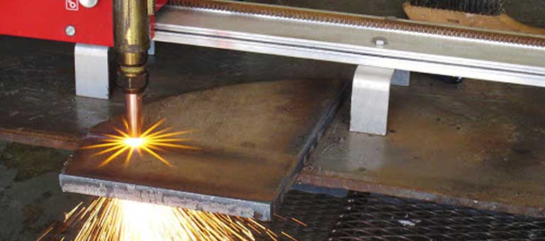 Close up of oxy-fuel cutting torch cutting thick metal.