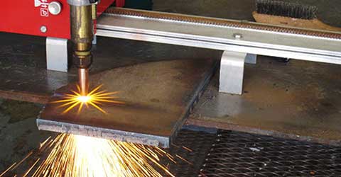 Close up of oxy-fuel cutting torch cutting thick metal.