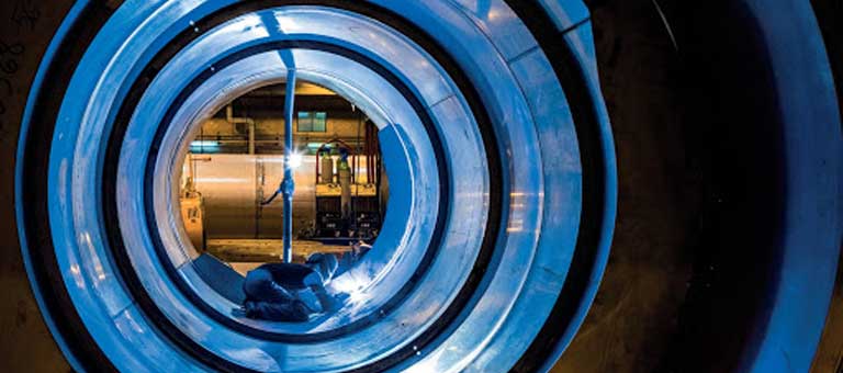 Welder, welding the inside of a giant pipe