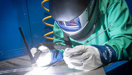 A TIG welder working in RADNOR Personal Protection Equipment