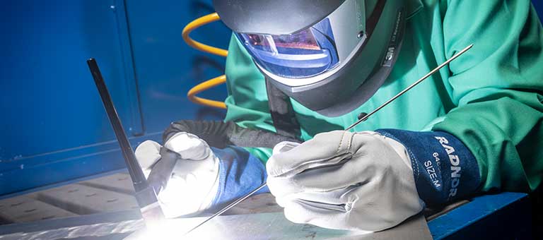 A TIG welder working in RADNOR Personal Protection Equipment