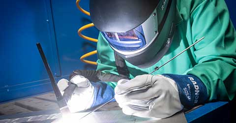 A TIG welder working in RADNOR Personal Protection Equipment.
