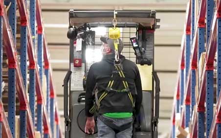 Five construction workers stand on a jobsite wearing personal protective equipment - PPE