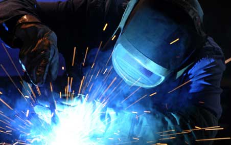 A welder concentrating on an intricate weld.
