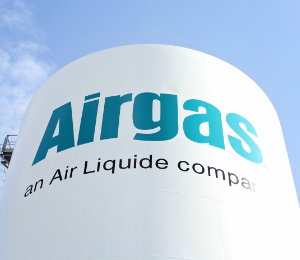 Looking skyward toward the top of a large white Industrial Storage Tank donning the Airgas logo
