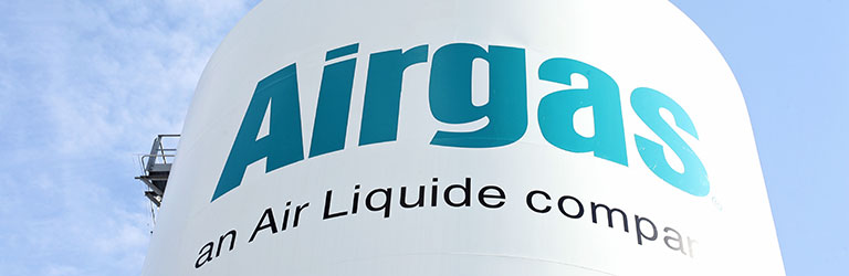 Looking skyward toward the top of a large white Industrial Storage Tank donning the Airgas logo