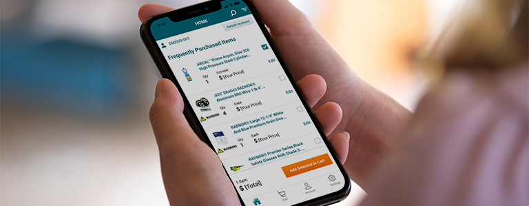Close up of a woman’s hands holding a smartphone with the teal Airgas Reorder App Welcome Screen on it.