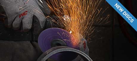 Sparks fly from a grinder operated by a worker in 3M protective gear.