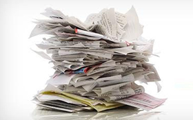 A messy stack of paper invoices and receipts on a white background