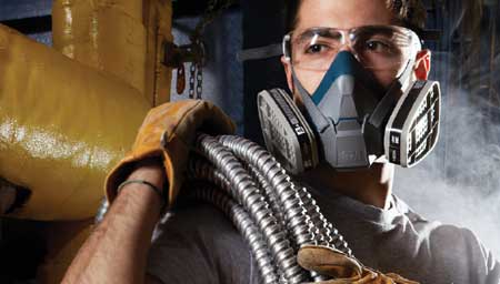A worker in a dusty environment wearing a 3M Respirator