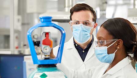 A technician flips the on/off switch on a SMARTOP Cylinder in a laboratory.