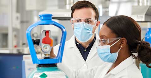 A technician flips the on/off switch on a SMARTOP Cylinder in a laboratory.