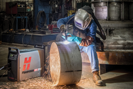 A man uses his Hypertherm Powermax105 SYNC(tm) system to cut a stell cylinder.