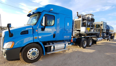 A blue truck hauling a nitrogen pumping equipment trailer