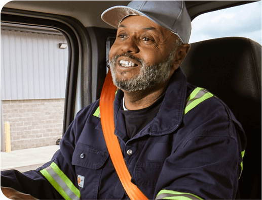 Airgas CDL truck driver sits in his truck cab smiling. 