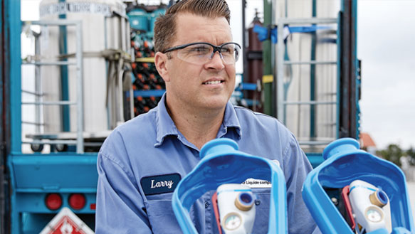 An Airgas representative delivering two cylinders of gas with SMARTOP cylinder heads