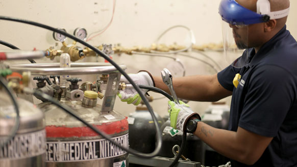 A gas technician changing out a liquid nitrogen cylinder