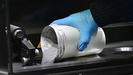 Metal powder being poured into a 3D printer