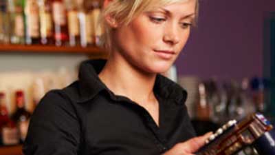 A bartender pouring a drink from the soda-gun.