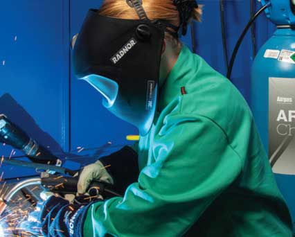 Welder, wearing welding helmet & welding gloves, MIG/GMAW welding stainless steel with ARCAL Chrome shielding gas.