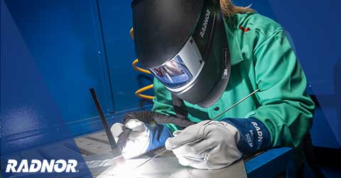 Welder using RADNOR welding tools and consumables, while wearing RADNOR welding helmet by 3M Speedglas, welding jacket and welding gloves.
