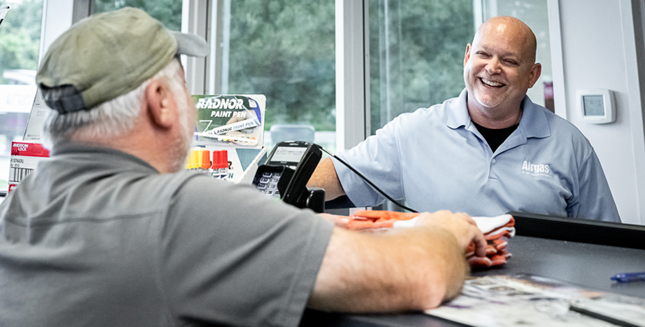 An Airgas retail branch associate interacts with a customer from behind the counter.