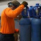 A worker moving gas cylinders
