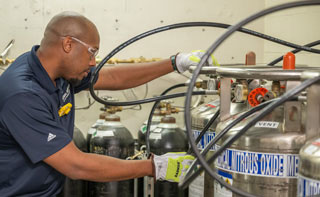 An installation expert maintaining liquid cylinders of medical gases